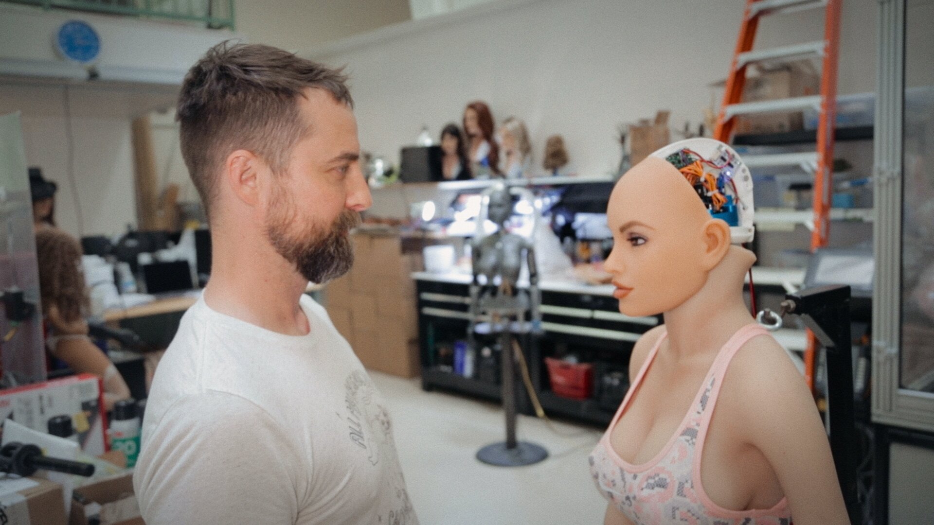 Protagonista stojí tváří v tvář rozpracovanému modelu robotky